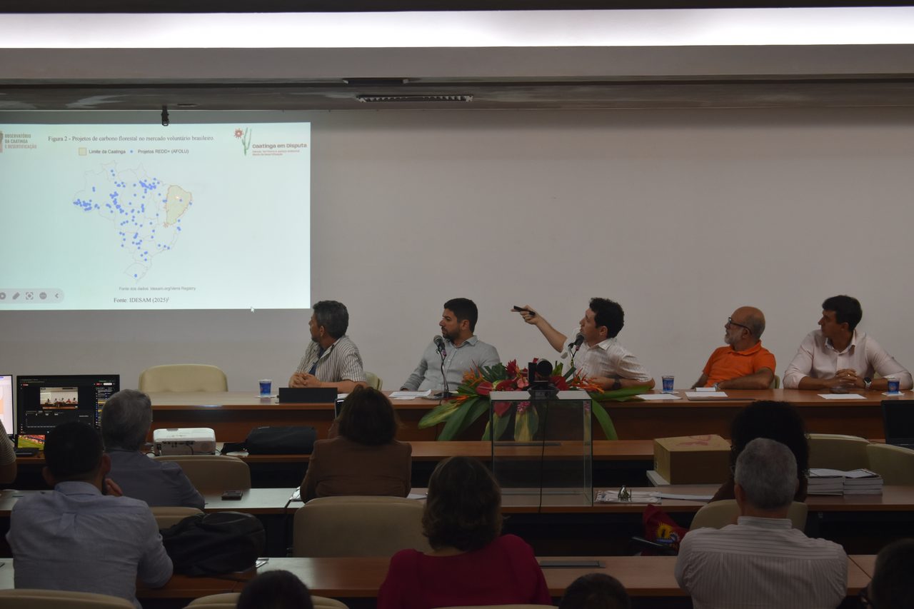 Palestra com plateia e projeção de um mapa da América do Sul